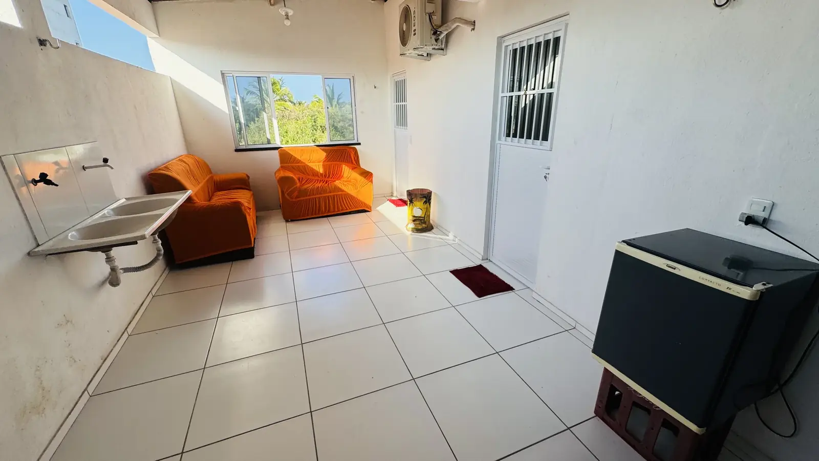 Área comum da pousada com mesa e bancos